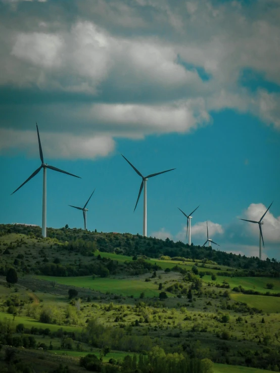 a bunch of windmills are being used on top of a hill