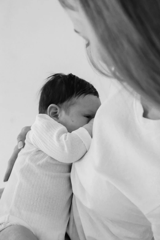 a woman is holding a sleeping baby in her arms