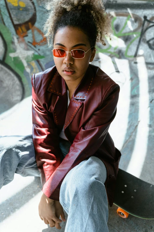 a girl wearing shades posing on top of a skateboard