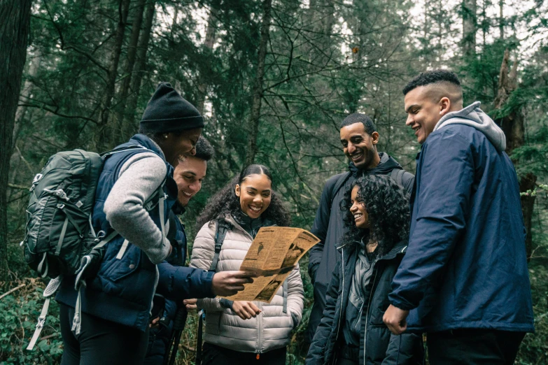 two people and three men stand in a forest together