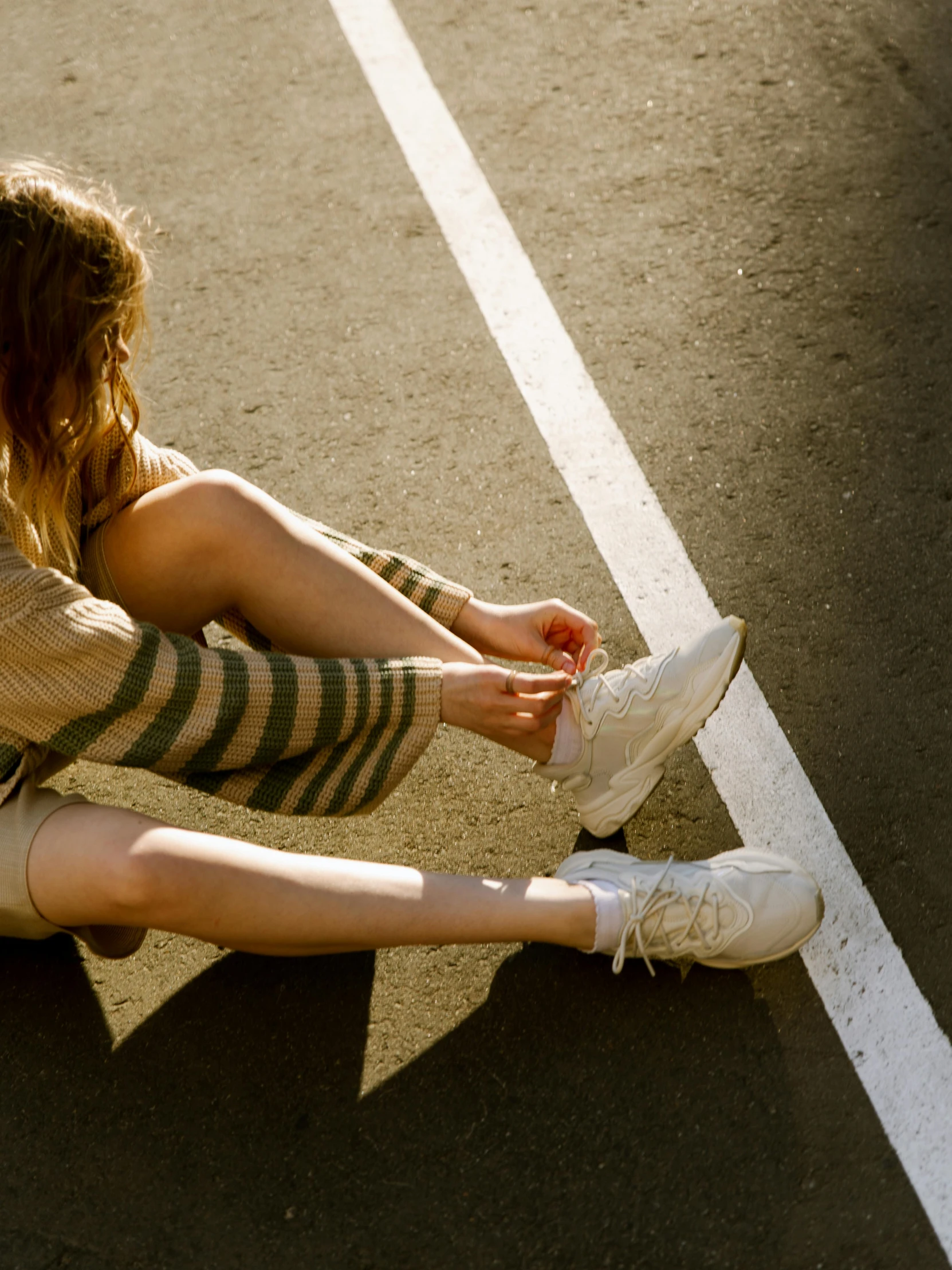 a young woman sitting on the ground with her shoes off