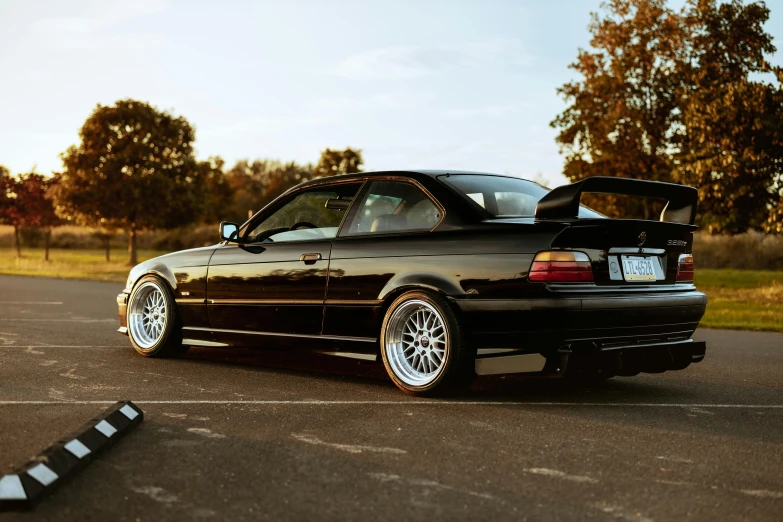 a car with its trunk up sitting in a parking lot