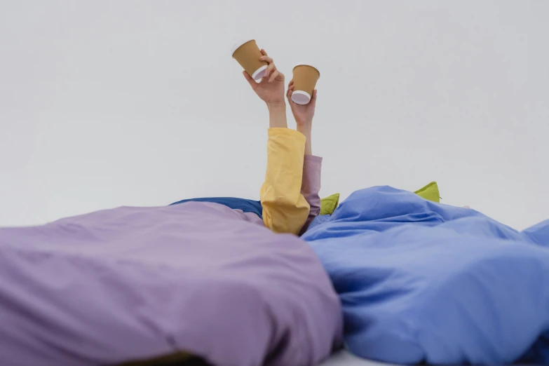 two people laying down in bed with pillows on the bed