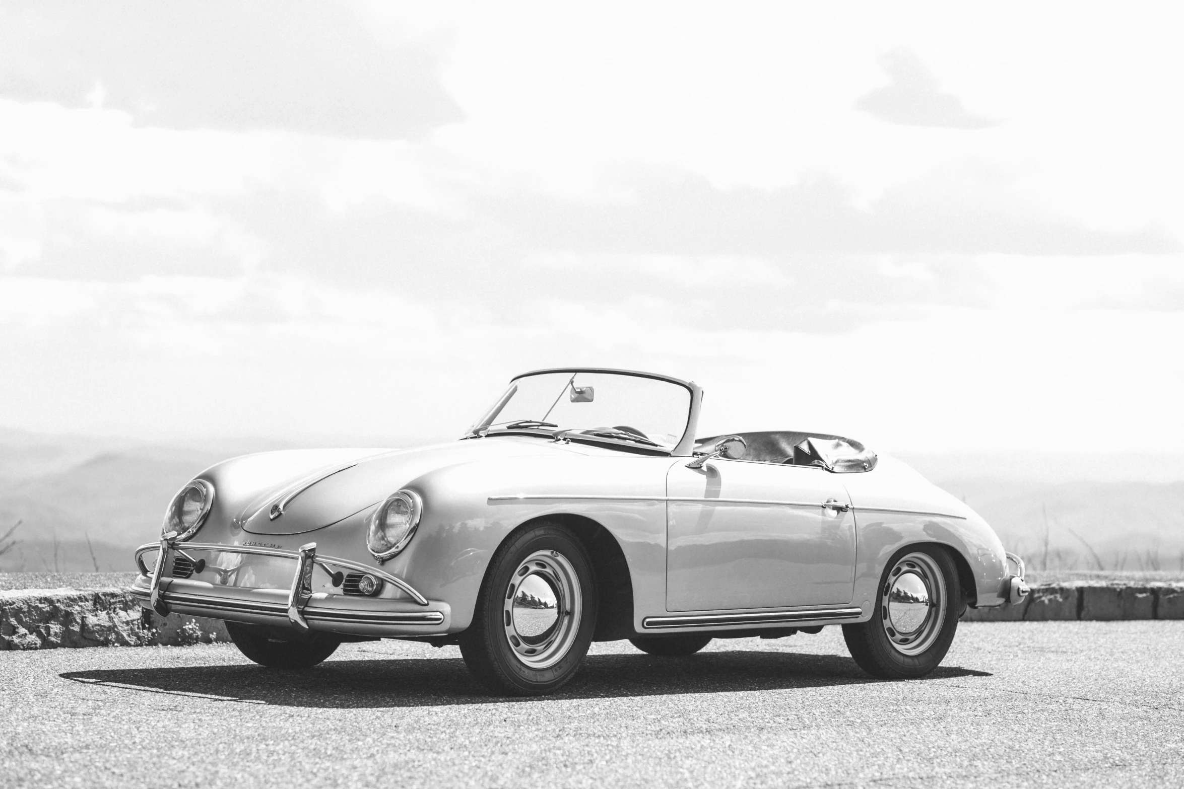 a gray car is parked by some mountains