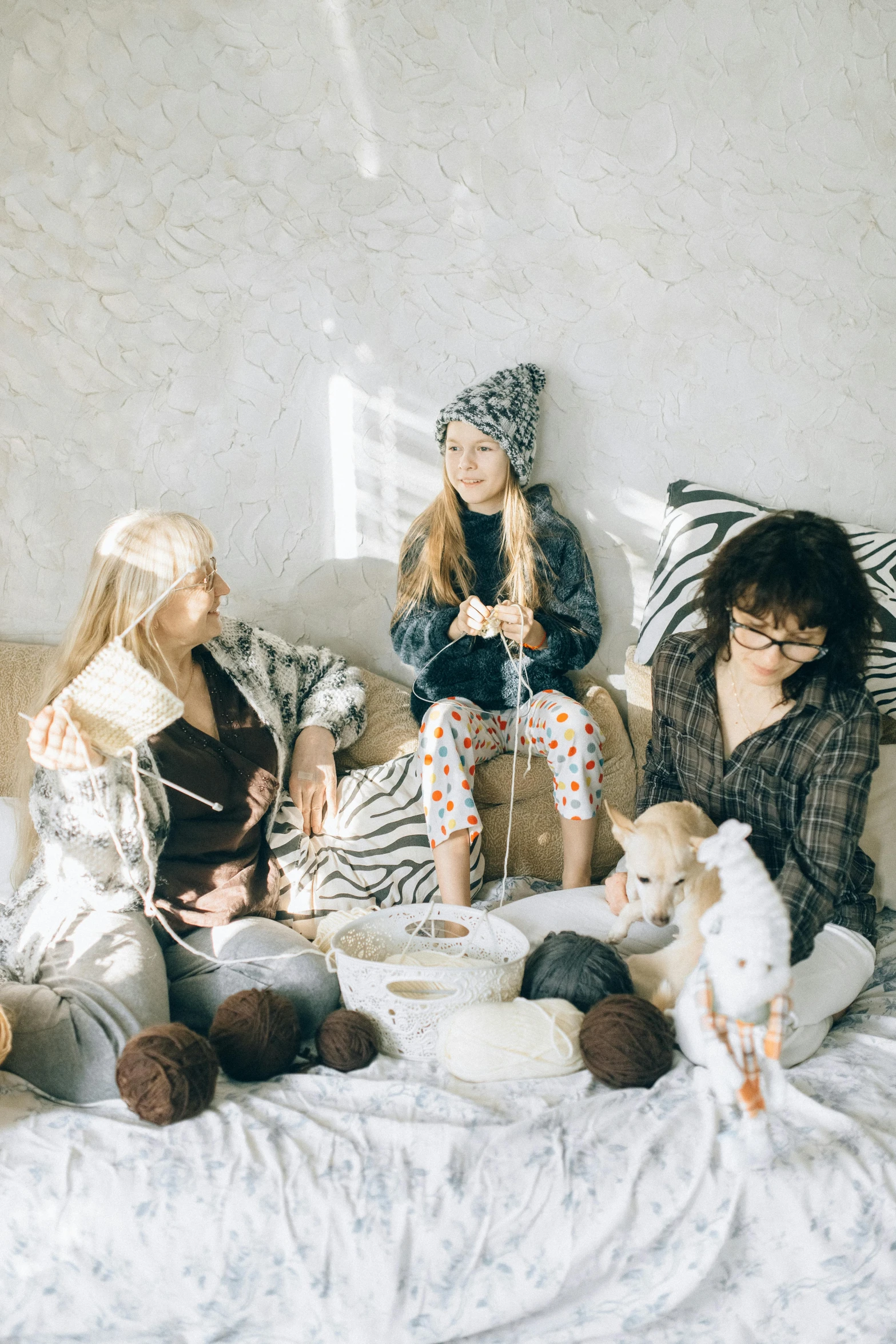 group of people sitting on bed with stuffed animals