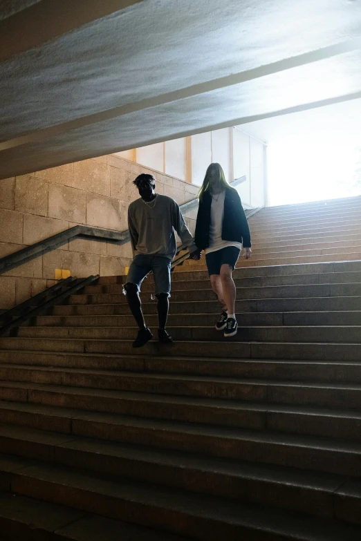 two people holding hands while walking up stairs