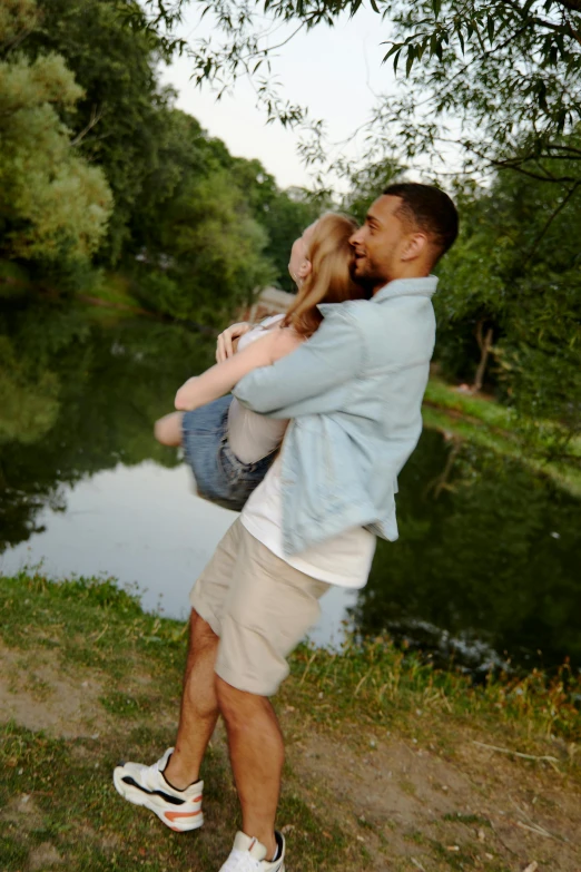 a couple taking a po with water and trees in the background