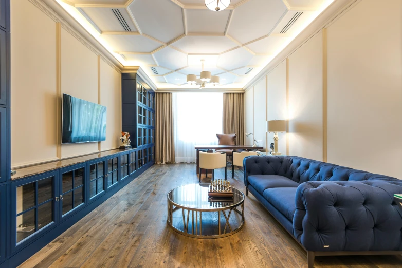 a living room with blue sofas sitting on top of wooden floors