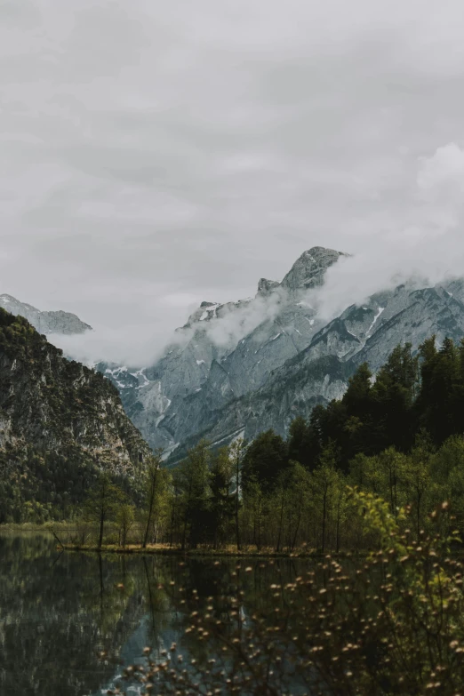 some mountains, one behind a lake, in the woods