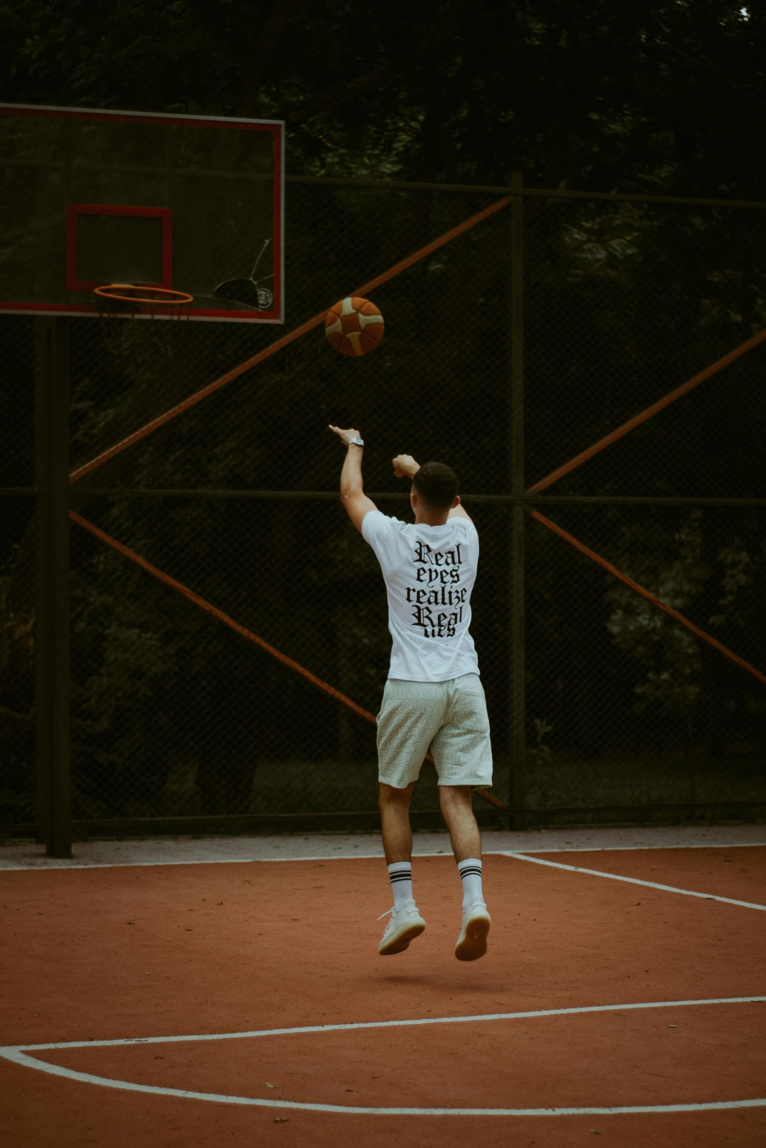 a man jumps high to get a basketball during a game