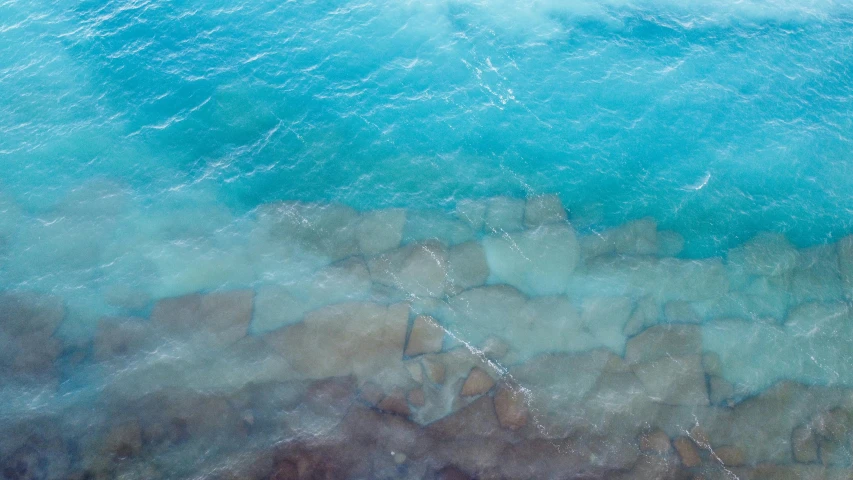 an aerial view of the sea with some blue water