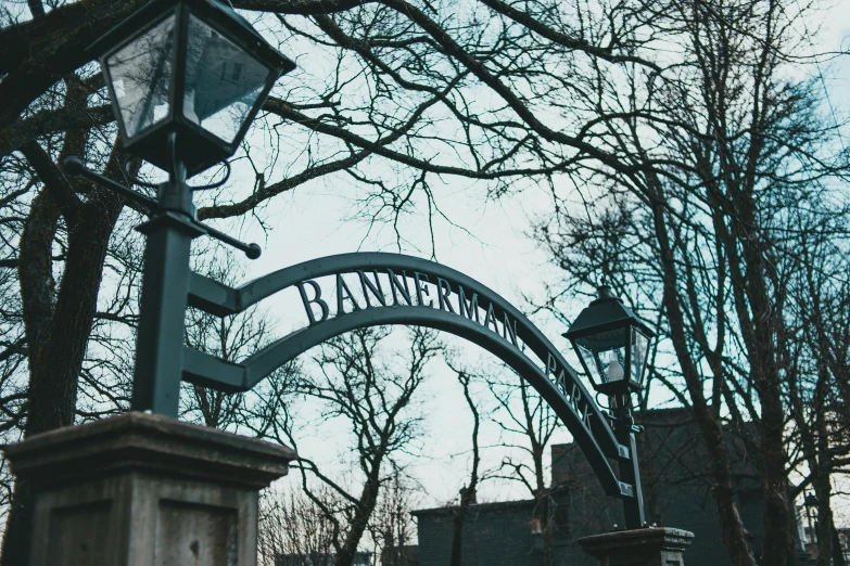 a street light is standing underneath a big metal sign