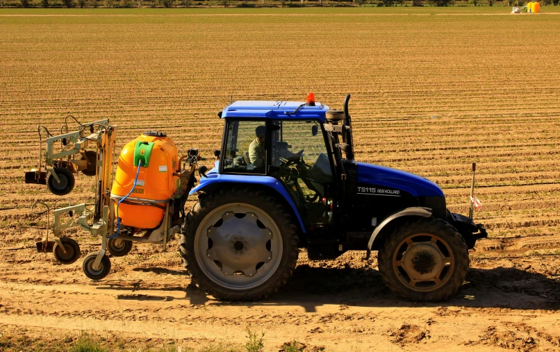 a tractor with a plow attachment in the middle of a field