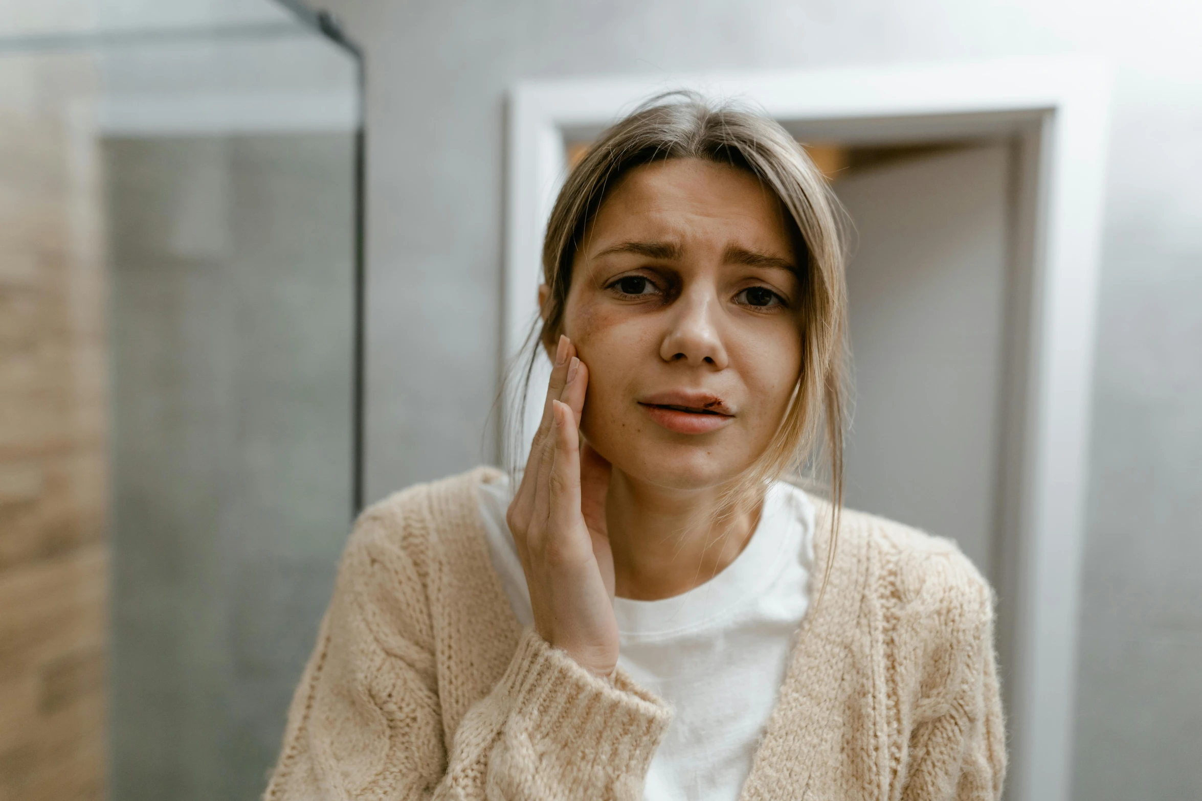 a woman is looking in the mirror with a concerned look