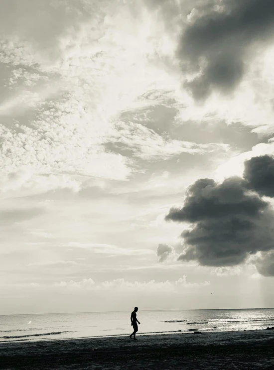 man running along the beach in front of some water