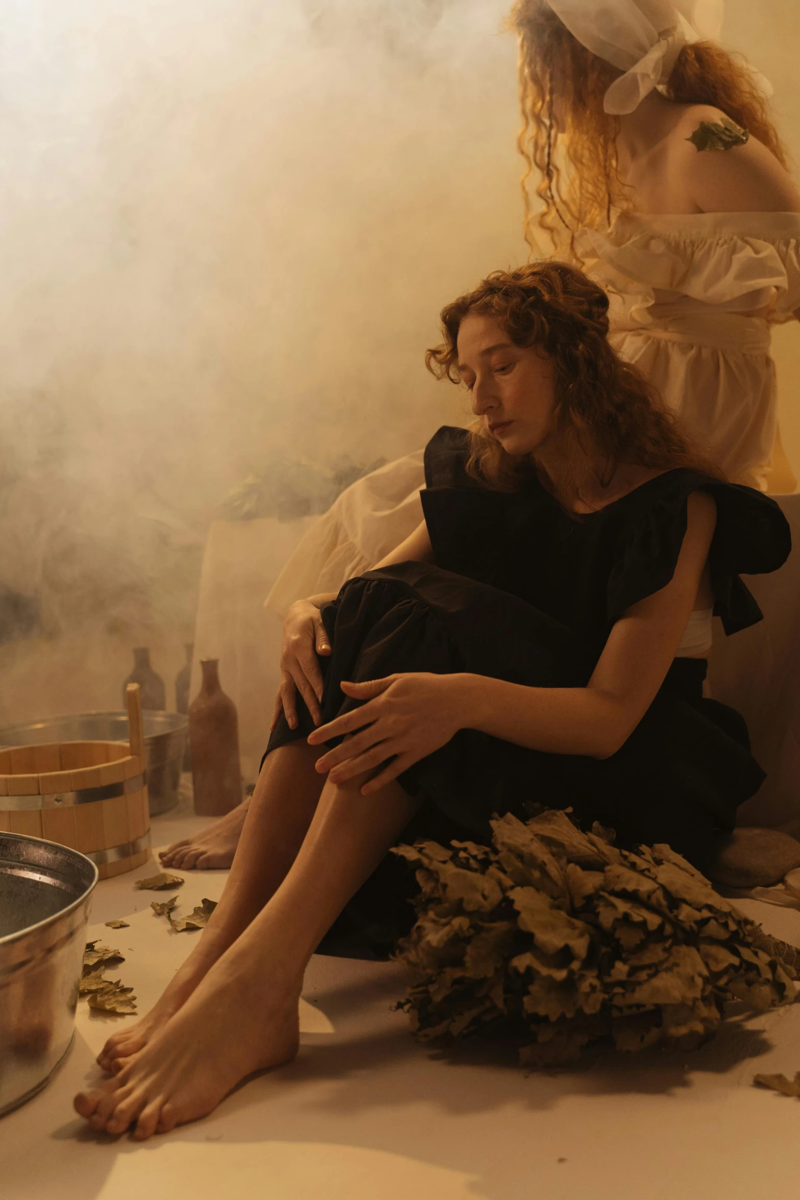 a woman sits on the floor in her bath tub looking at a cell phone