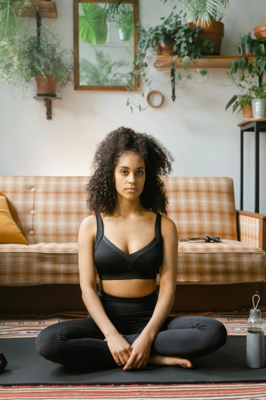 a woman sitting in front of a couch in yoga