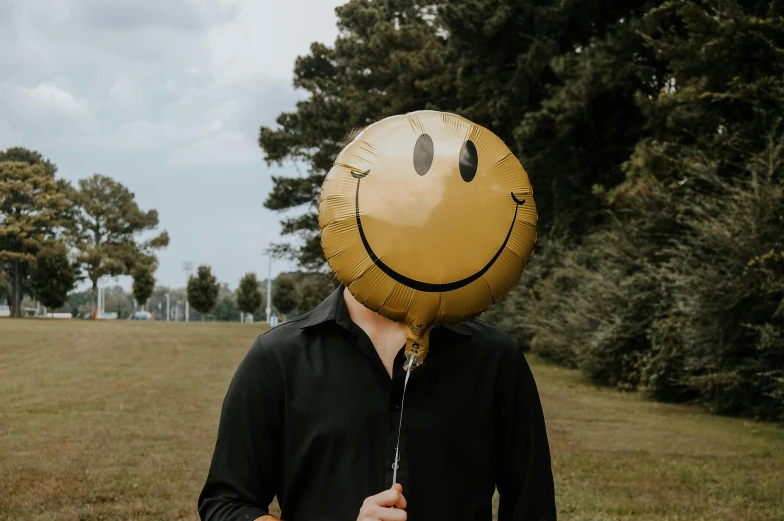 a person with a smiley face balloon on their head
