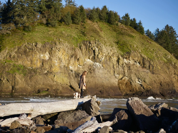 a person standing on a wooden bridge over some rocks