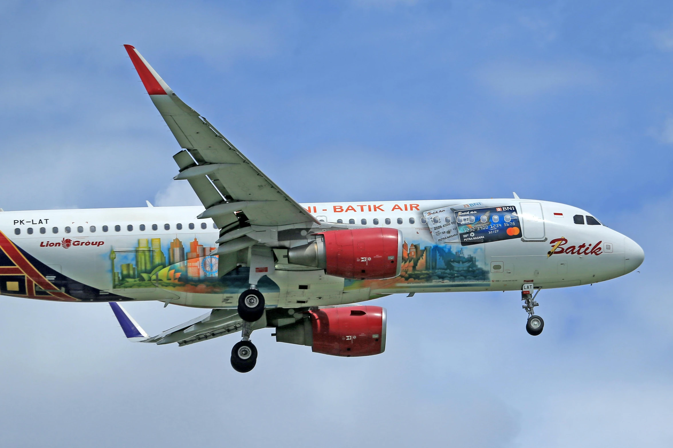 a colorful, large jetliner flying through a cloudy sky