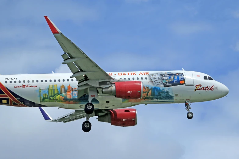 a colorful, large jetliner flying through a cloudy sky