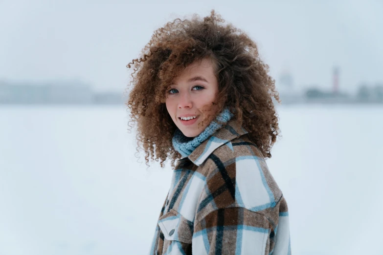 there is a woman with very curly hair standing in the snow