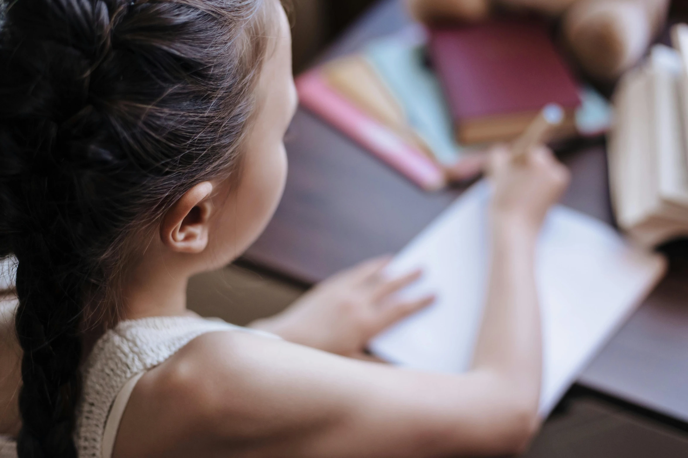 a  writes on a notebook beside some teddy bear