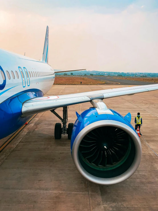 an air plane on the runway with a small truck nearby