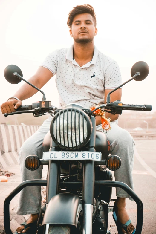 a man sitting on a motorcycle while wearing blue pants