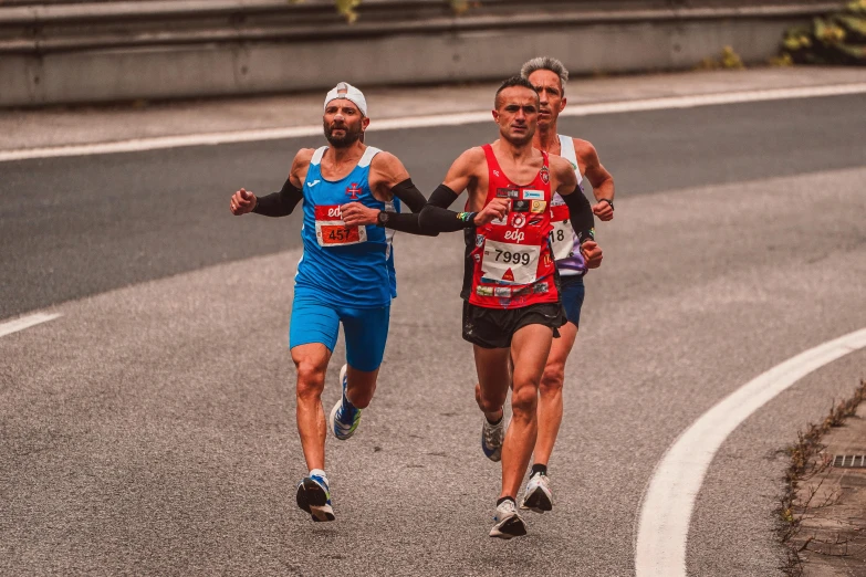 two men are running down a street next to each other