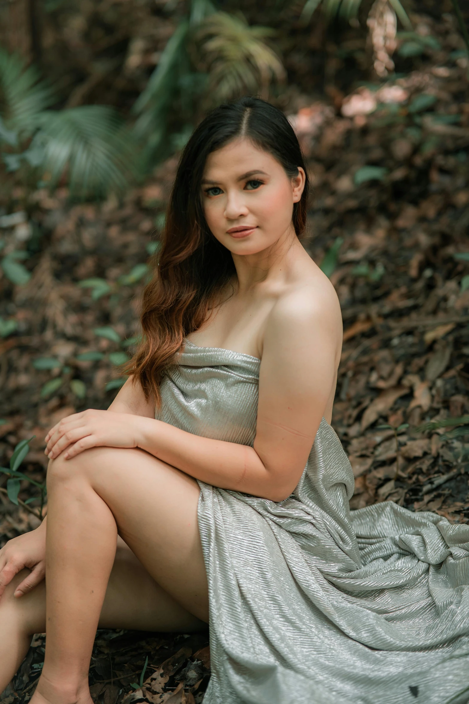 a woman posing in a dress in the woods