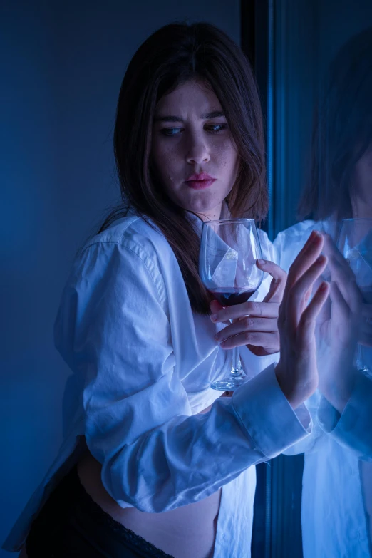 a woman is holding a glass of wine in her hand