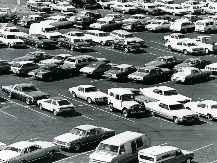 many trucks are parked in a lot full of other cars