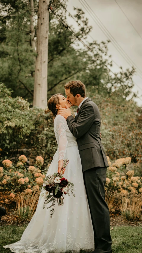 a couple is emcing outside in a field