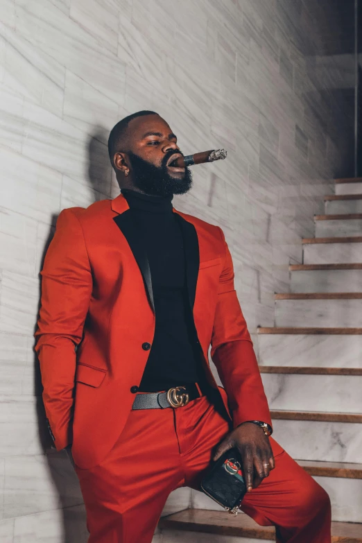 a man dressed in a bright red suit and smoking a cigarette