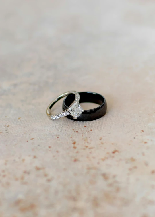 two engagement rings with diamond accents are set on a marble table