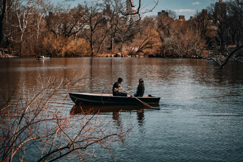 four people in a small boat on a body of water
