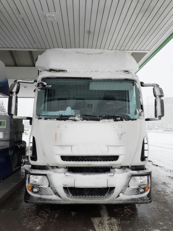 a big white truck is under a covered area