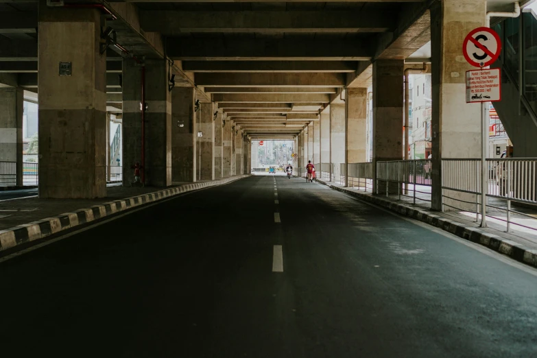 an empty road is shown under the overpass