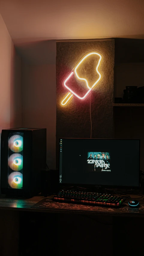 laptop computer with ice cream on it sitting in front of a neon sign