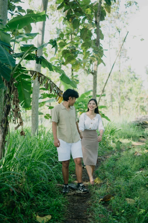 a young couple stand beside each other in a jungle