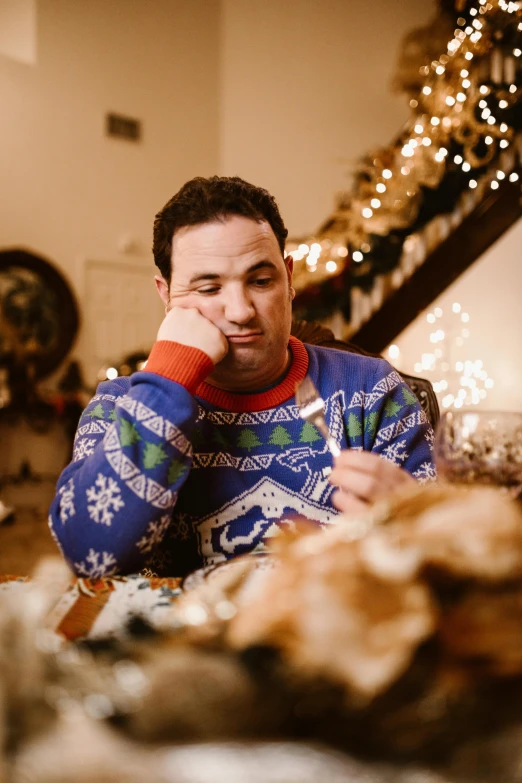 a man who is sitting down at a dinner table with a pen in his mouth