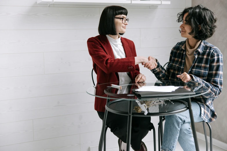 a couple of people sitting at a glass table