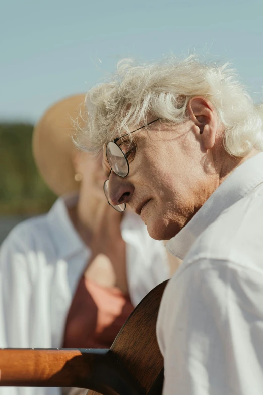 an elderly man with white hair playing guitar