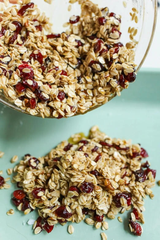 a glass bowl of granola and three packets of granola