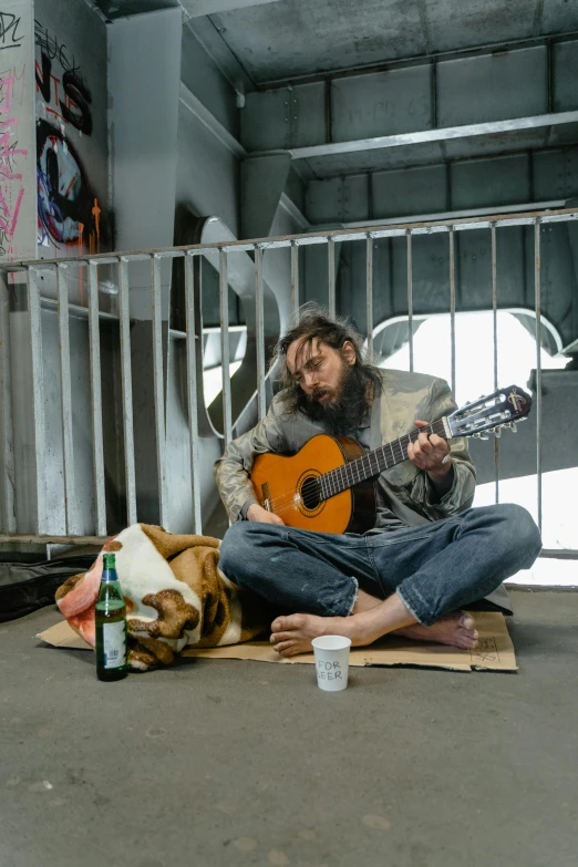 a man playing a guitar while sitting on the floor