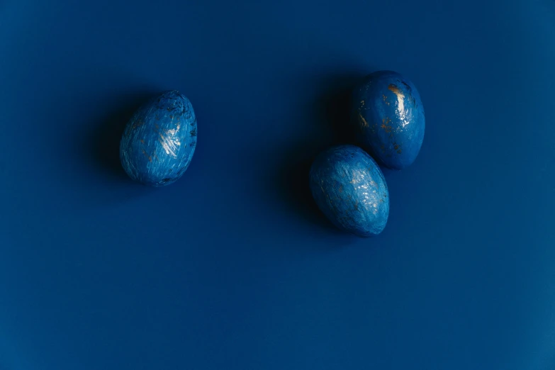 three eggs are arranged on a blue background