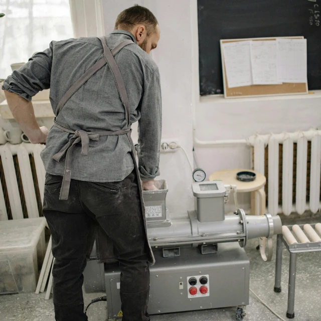 a man standing at a machine making soing