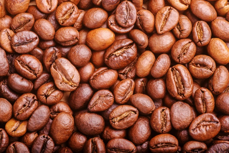 some coffee beans and brown ones scattered over them