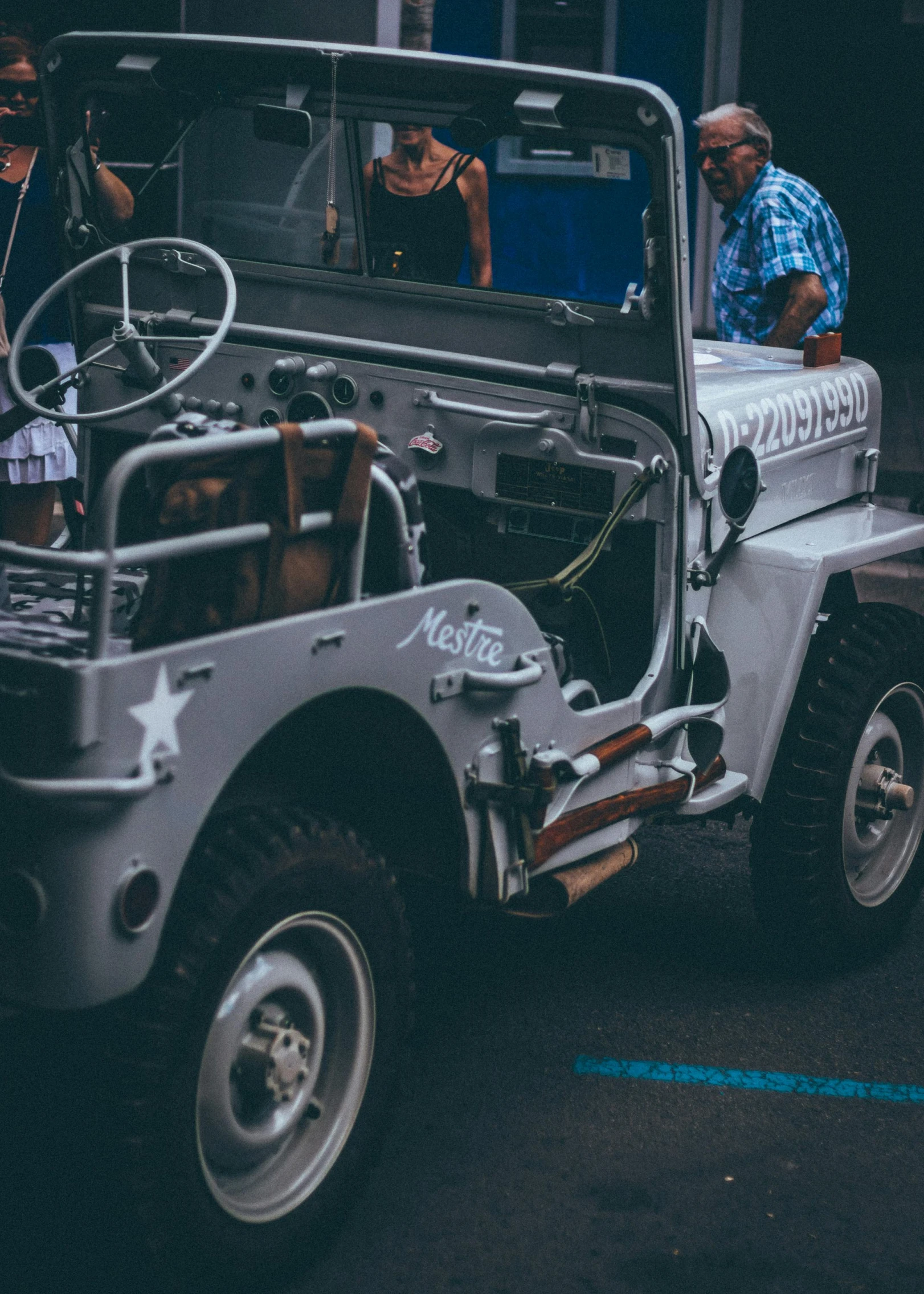 several people are standing around a jeep